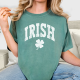 Person wearing a green 'IRISH' t-shirt with a shamrock on a neutral background