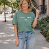 Woman wearing a green t-shirt with 'ABSOLUTELY NOT.' text on a city street.