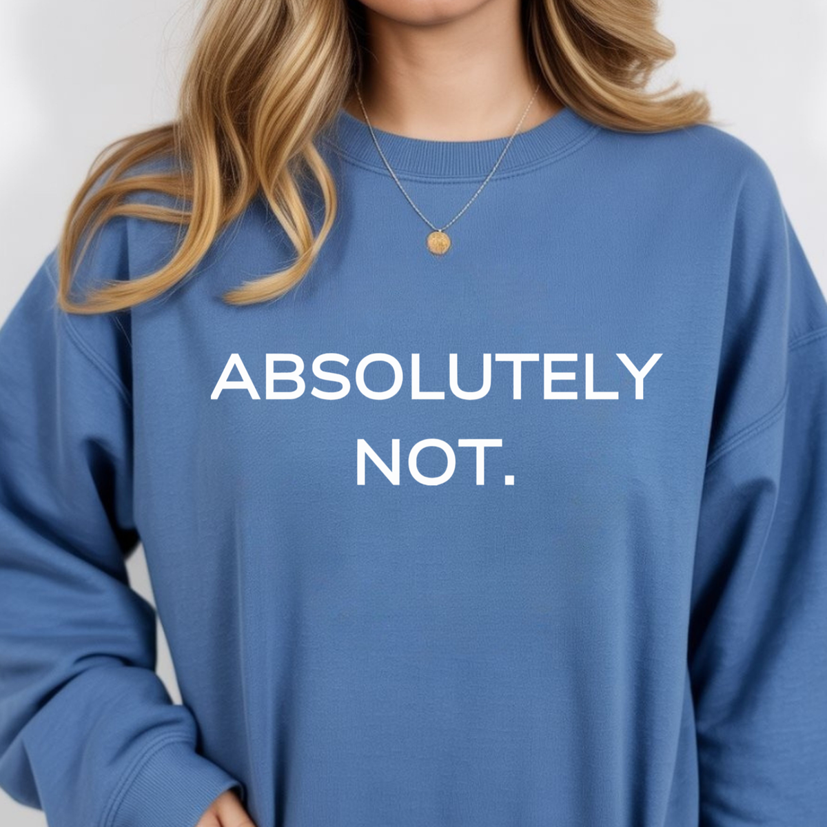 A woman wearing a blue sweatshirt with 'ABSOLUTELY NOT.' text on a plain background