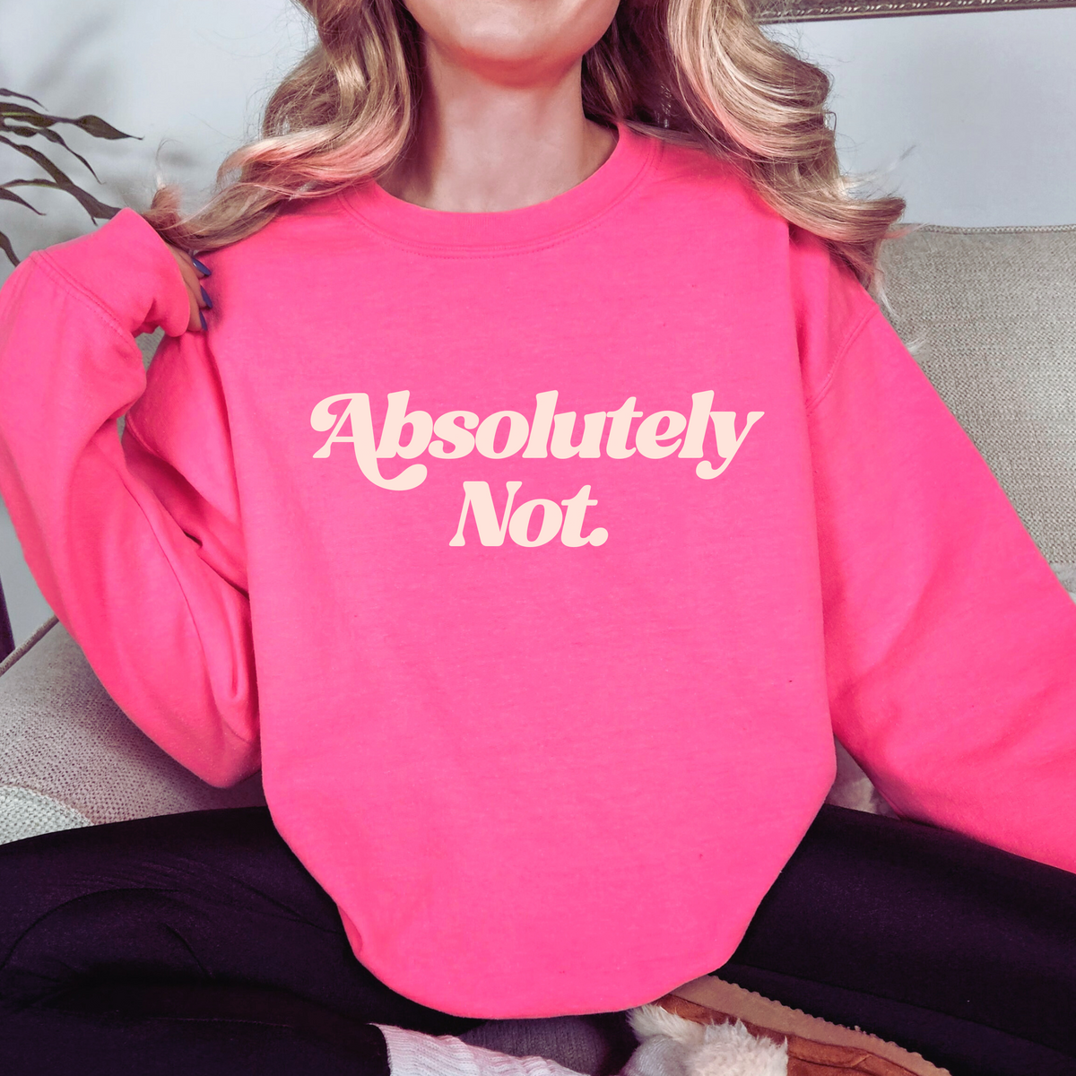 Person wearing a pink sweatshirt with 'Absolutely Not.' text.