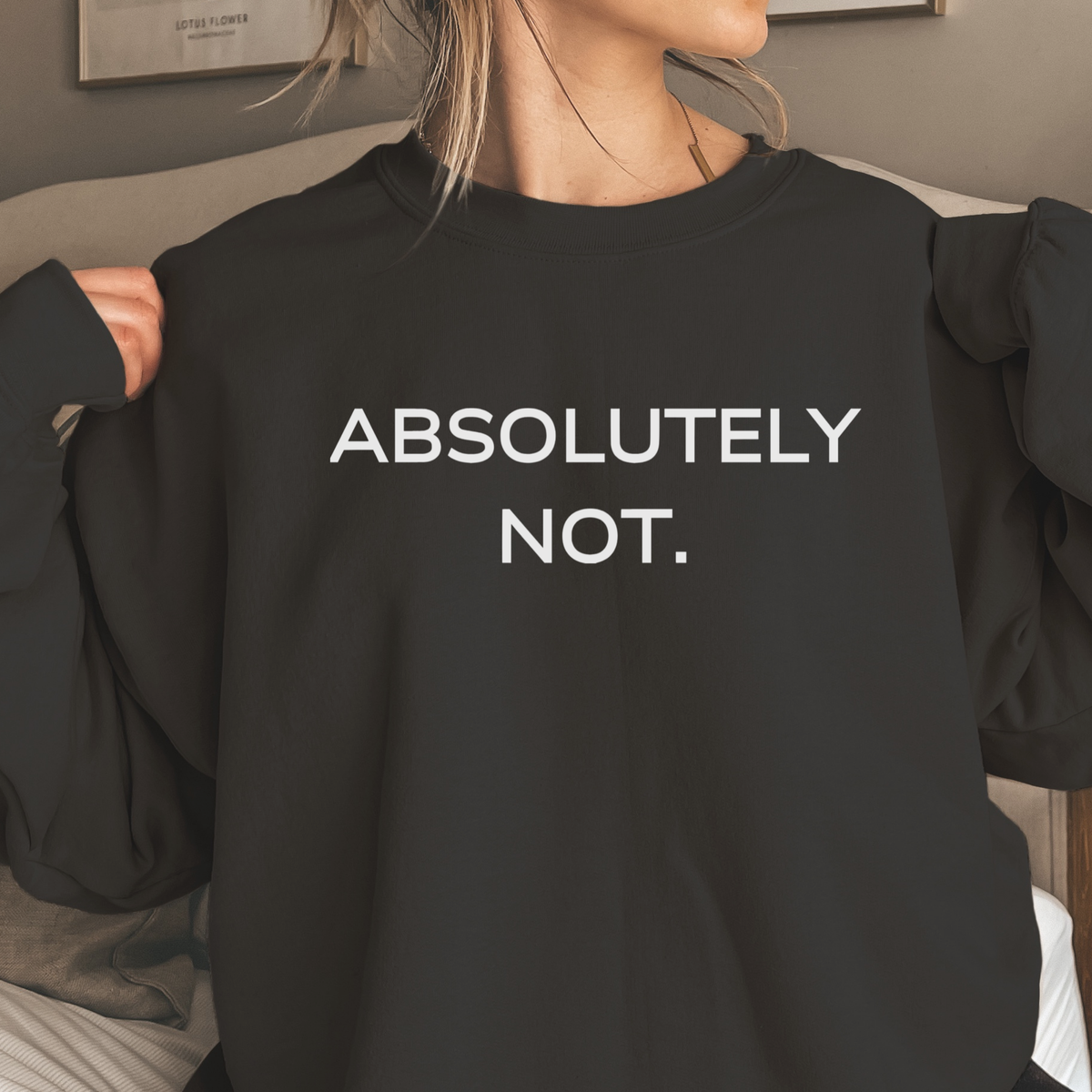 Person wearing a black sweatshirt with 'ABSOLUTELY NOT.' text.