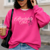 A woman wearing a bright pink crewneck sweatshirt with the text 'Absolutely Not.' in white script and a small black graphic, paired with a black baseball cap, blue jeans, and a black shoulder bag while holding an iced coffee.