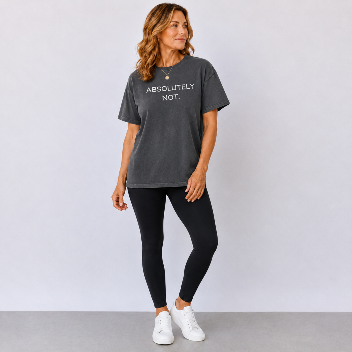 A woman standing in a faded black t-shirt that says "Absolutely Not"