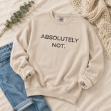 A beige crewneck sweatshirt with the text 'ABSOLUTELY NOT.' printed in black across the chest, styled in a flat lay with blue jeans, a green eucalyptus sprig, and a cream knit blanket.
