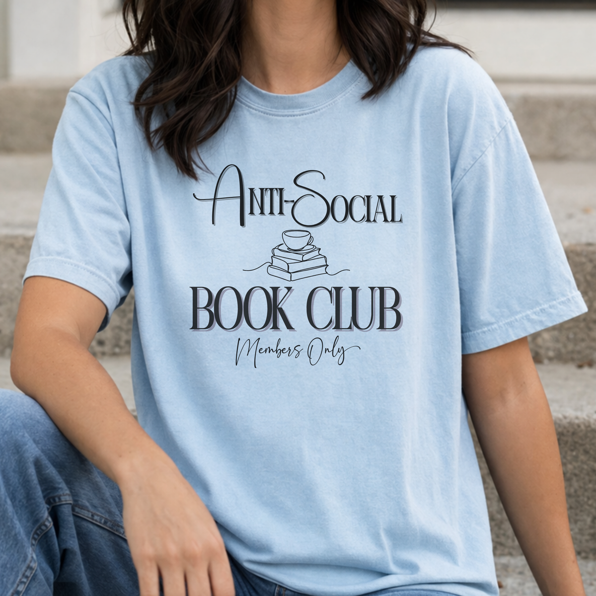 Person wearing a light blue t-shirt with 'Anti-Social Book Club Members Only' text.