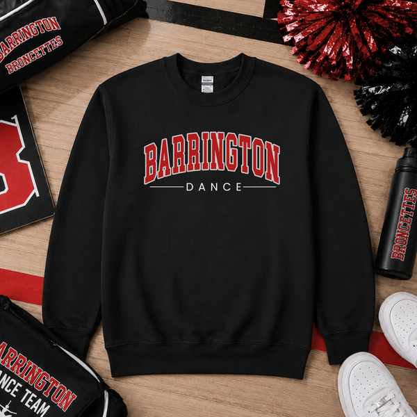 A black crewneck sweatshirt with 'BARRINGTON DANCE' printed in red and white on the chest, styled in a flat lay with cheerleaders, a water bottle, and white sneakers on a wooden floor.