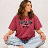A woman sitting cross-legged wearing a faded burgundy t-shirt with 'BARRINGTON BRONCITIES' printed in black and white with a red silhouette, paired with light blue jeans and white sneakers.