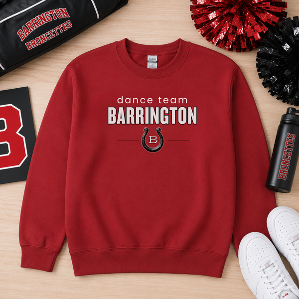 A red crewneck sweatshirt with 'dance team BARRINGTON' and a horseshoe logo printed on the front, styled in a flat lay on a light wood background with cheerleaders, a water bottle, and white sneakers.