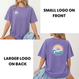Purple t-shirt with a smaller logo on the front and a larger logo on the back, worn by a person.