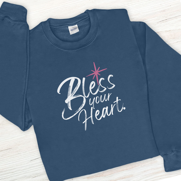 Blue sweatshirt with 'Bless your Heart' text on a wooden surface
