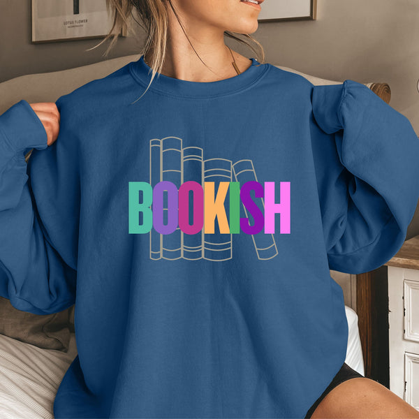 Person wearing an indigo blue sweatshirt with 'BOOKISH' text in colorful letters.
