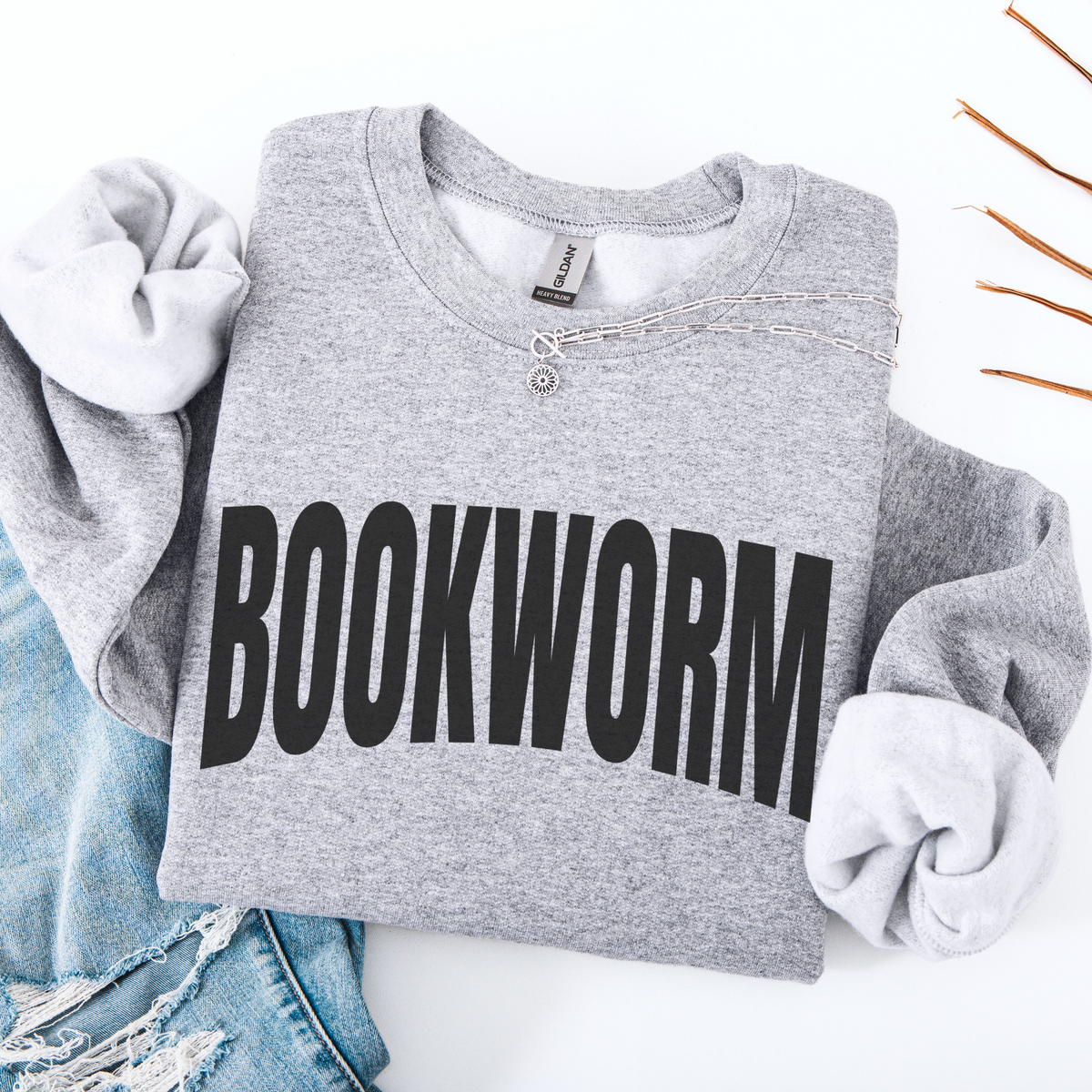 Gray folded sweatshirt with 'BOOKWORM' text on a white background