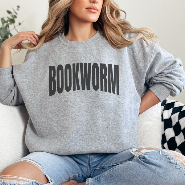 Person wearing a gray sweatshirt with 'BOOKWORM' text, sitting on a couch.