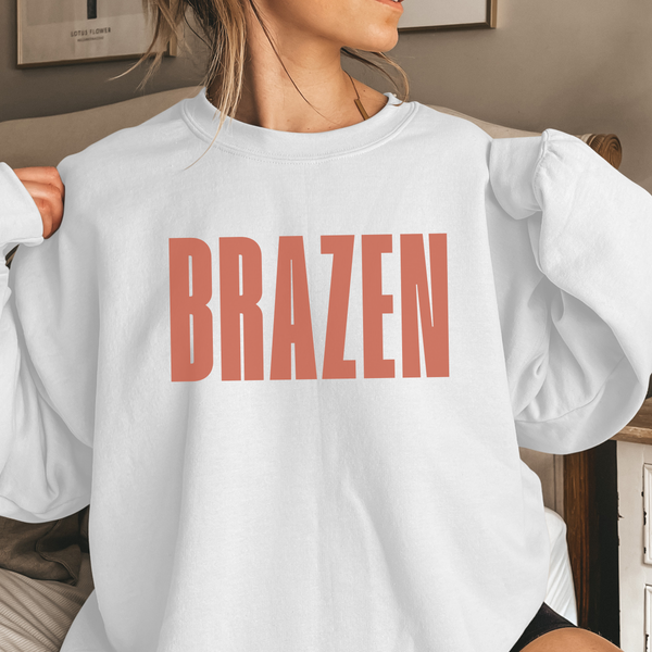 White sweatshirt with 'BRAZEN' printed in red on a neutral background