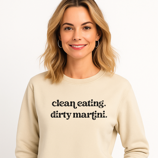 Woman wearing a beige sweatshirt with 'clean eating, dirty martini.' text on a white background