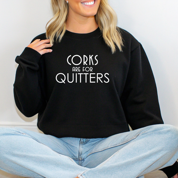 Person wearing a black sweatshirt with 'Corks are for Quitters' text.