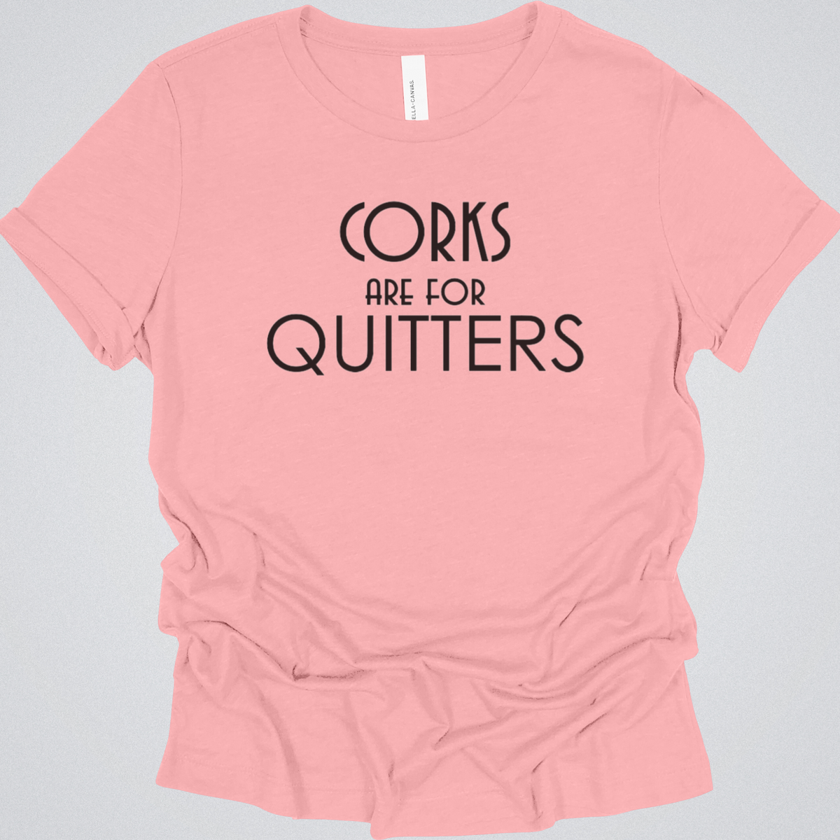 Pink t-shirt with 'Corks are for Quitters' text on a gray background