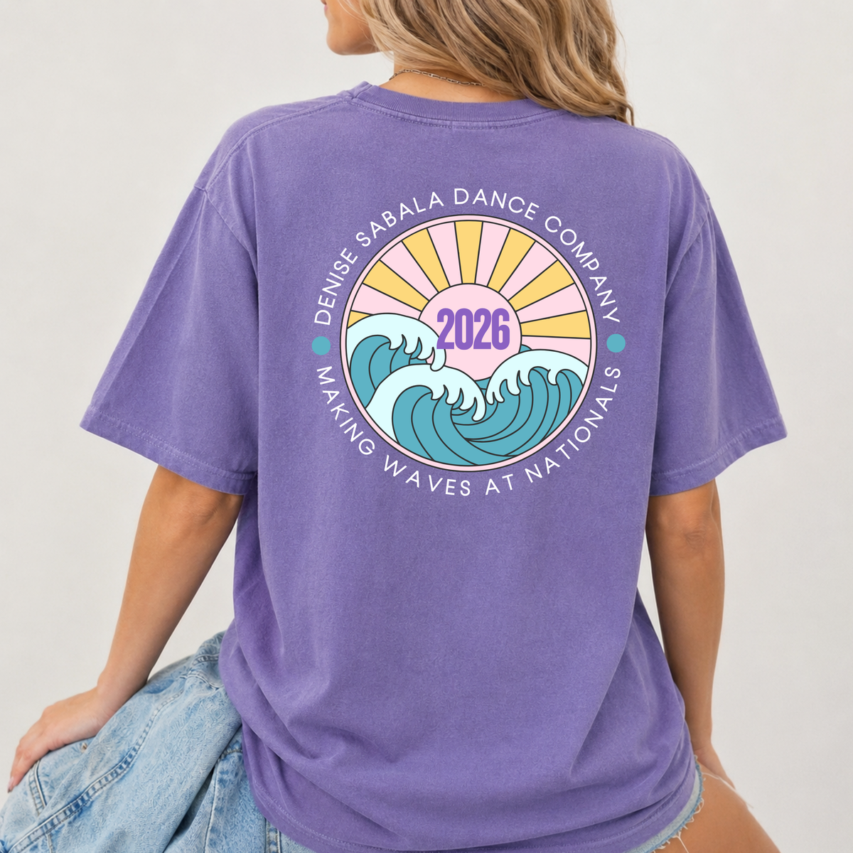 Person wearing a purple t-shirt with a design on the back, featuring text and graphics.
