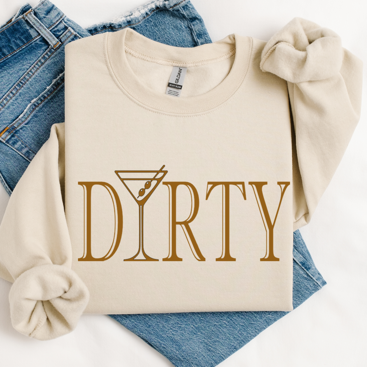 Beige sweatshirt with 'DIRTY' print on blue jeans. The letter "i" in 'martini' is a martini glass.