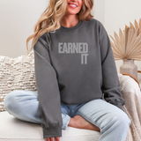 Woman wearing a gray sweatshirt with the words 