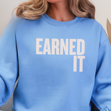 A close up of a woman in a light blue sweatshirt with the words 
