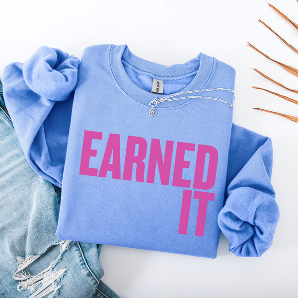 Light blue sweatshirt with 'Earned It' in pink text on a white background
