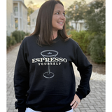 Woman wearing a black sweatshirt with 'Espresso Yourself' text and coffee cup graphic.