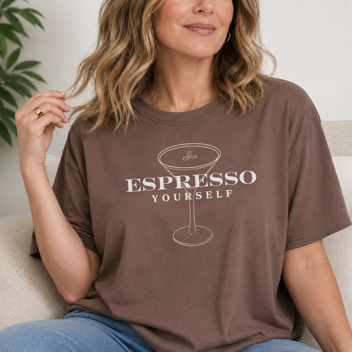 Woman wearing a brown t-shirt with 'Espresso Yourself' text and espresso cup graphic.