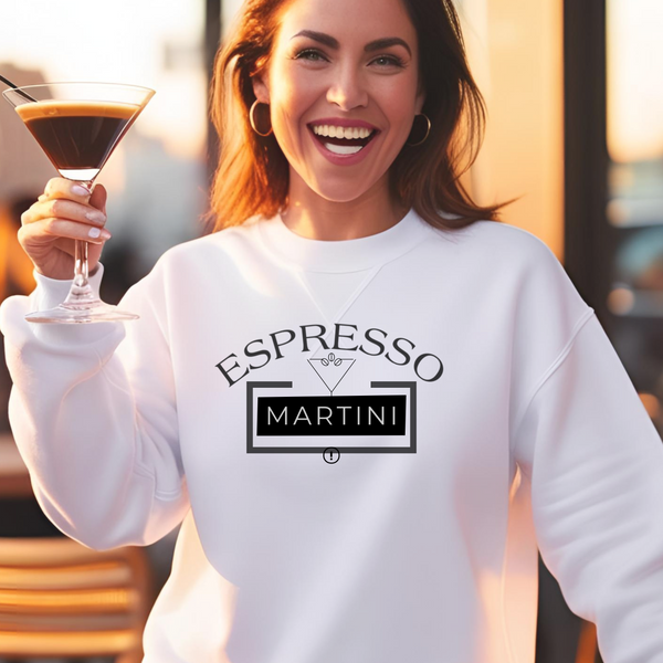 Woman in a white sweatshirt holding an espresso martini with the words "Espresso Martini" in black.