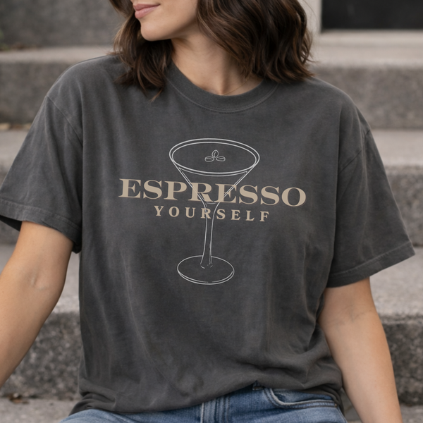 Person wearing a dark gray t-shirt with 'Espresso Yourself' design.