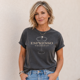 Woman wearing a dark gray t-shirt with 'Espresso Yourself' text and graphic, standing against a plain background.