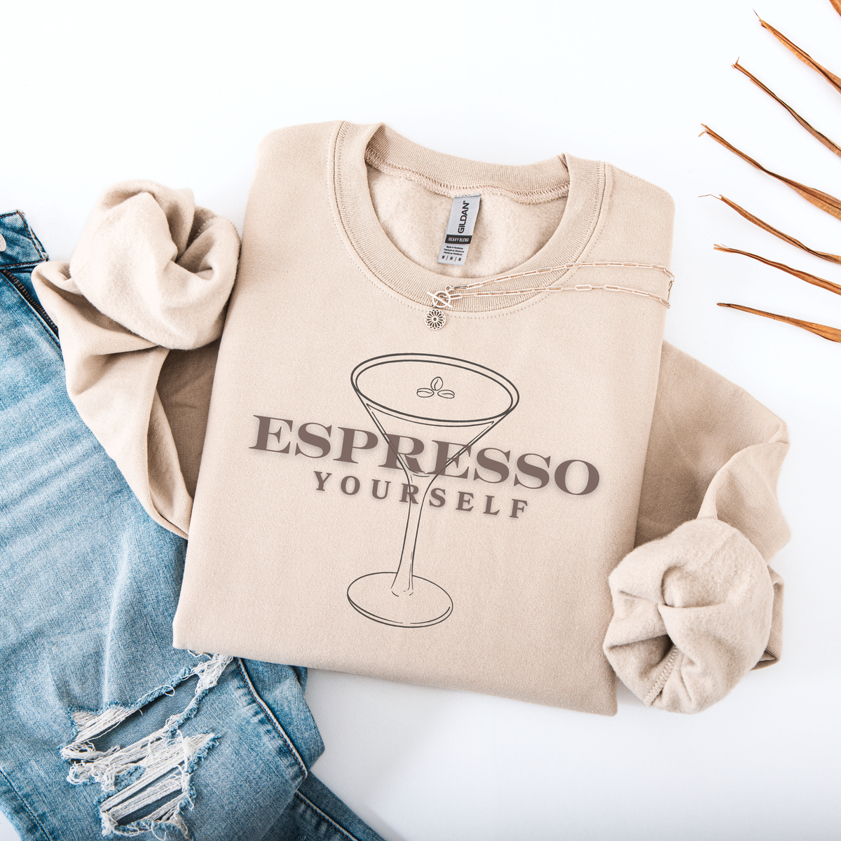 Beige sweatshirt with 'Espresso Yourself' text and martini glass graphic on a white background.