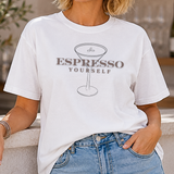 A woman wearing a white t-shirt with 'Espresso Yourself' design outdoors.