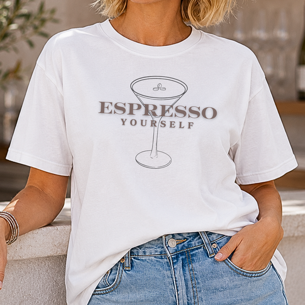 A woman wearing a white t-shirt with 'Espresso Yourself' design outdoors.
