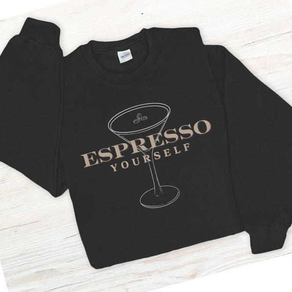 Black sweatshirt with 'Espresso Yourself' text and martini glass graphic on a white wooden surface