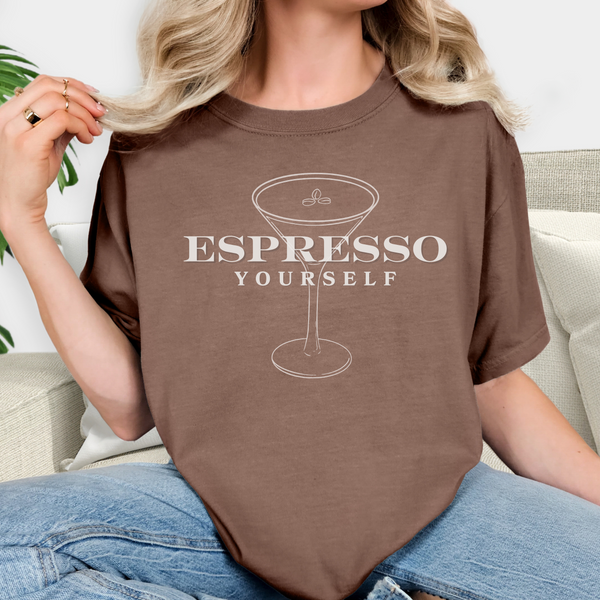 Person wearing a brown t-shirt with 'Espresso Yourself' design.