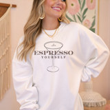 Woman wearing a white sweatshirt with 'Espresso Yourself' design in a casual setting.