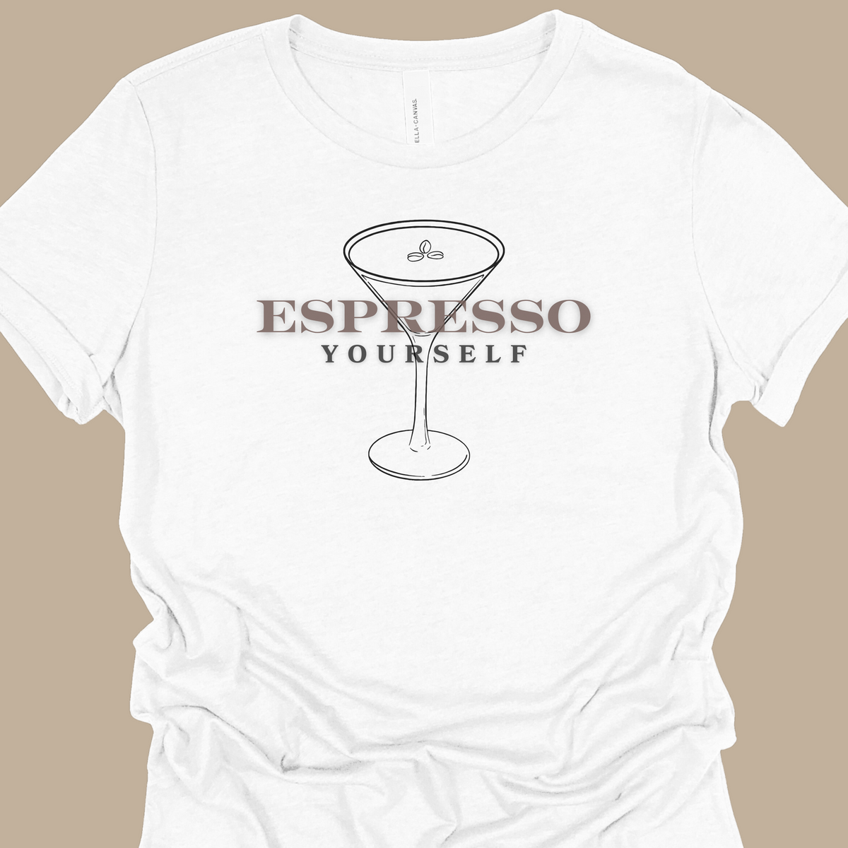 A white T-shirt with the words "Espresso Yourself" in black & brown writing.