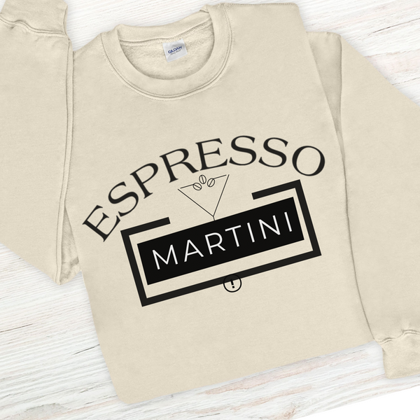 Beige sweatshirt with 'Espresso Martini' text design on a light wooden surface