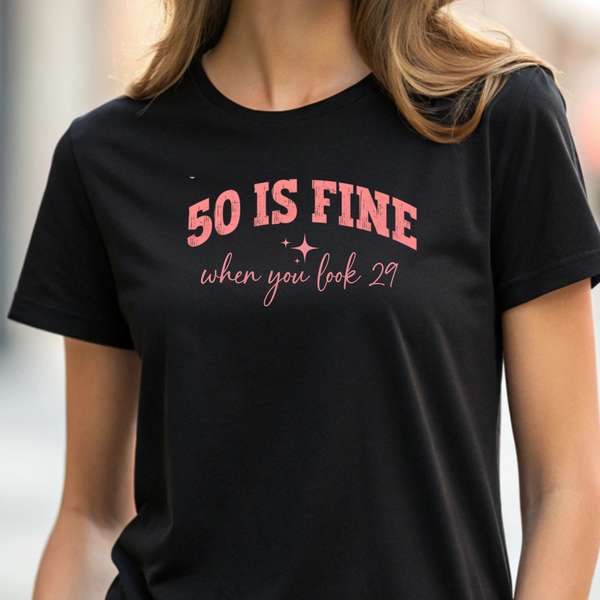 Person wearing a black t-shirt with pink text '50 IS FINE when you look 29'.