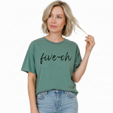Woman wearing jeans and a green Comfort Colors t-shirt with 'five-oh' text on a white background