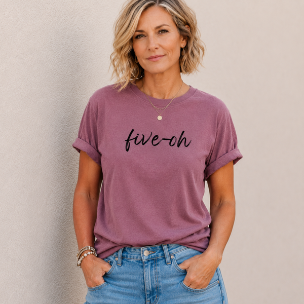 Woman wearing a berry purple t-shirt with 'five-oh' text against a plain background