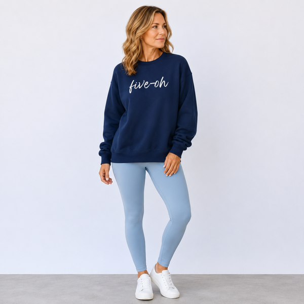 Woman wearing a navy sweatshirt with 'five-oh' text and light blue leggings on a white background