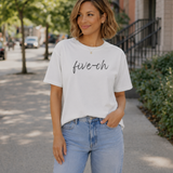 A woman standing outside with a white t-shirt one that says 