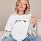 Woman wearing a white t-shirt with 'five-oh' text, sitting on a beige couch.