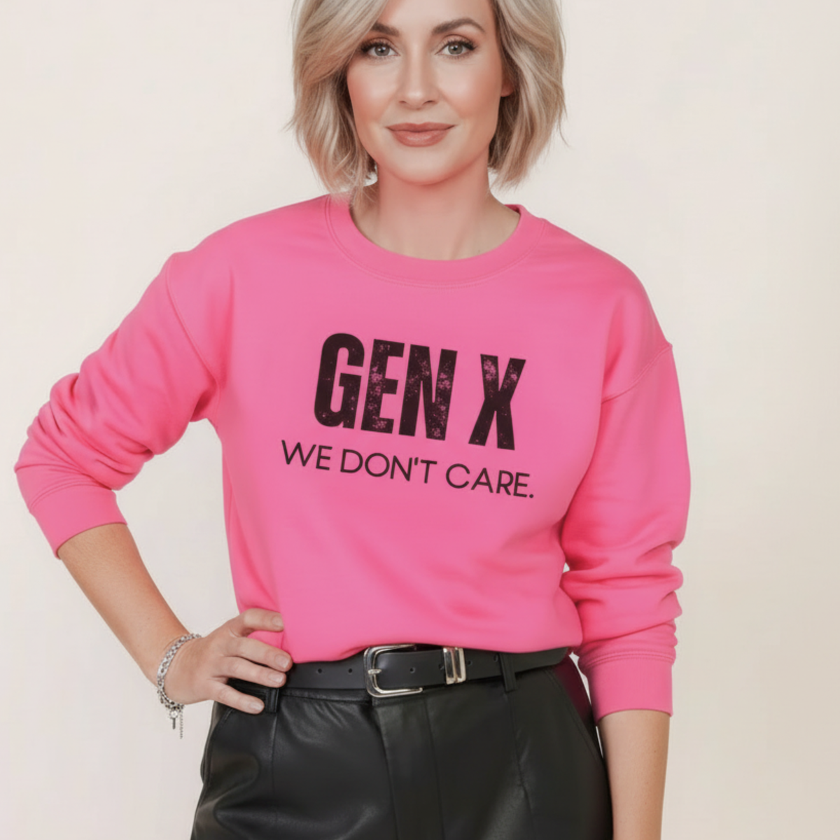 A woman wearing a pink sweatshirt with 'GEN X WE DON'T CARE' text on a plain background