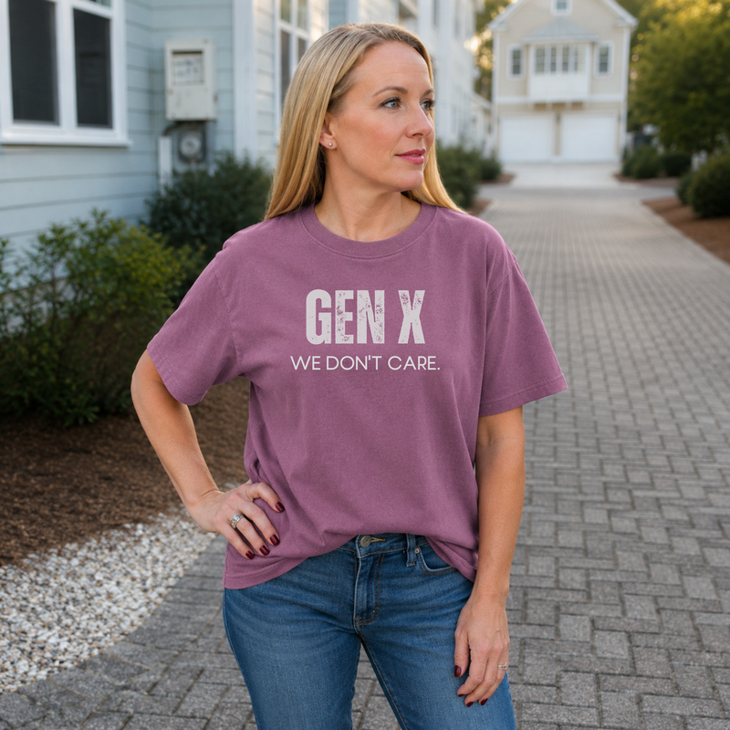 A woman standing outside in a berry tee shirt on that says "Gen X: We Don't Care"