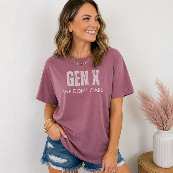 A woman standing  in a berry colored tee shirt on that says "Gen X: We Don't Care."