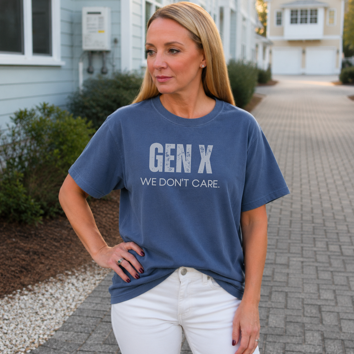 A woman standing outside in a navy blue tee shirt on that says "Gen X: We Don't Care."