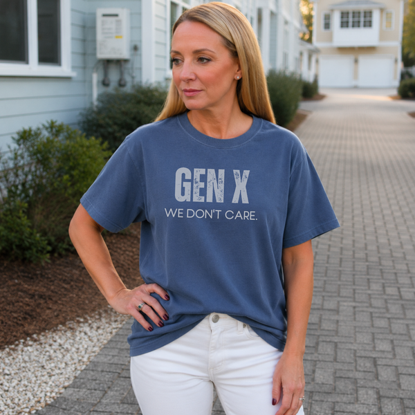 A woman standing outside in a navy blue tee shirt on that says "Gen X: We Don't Care."